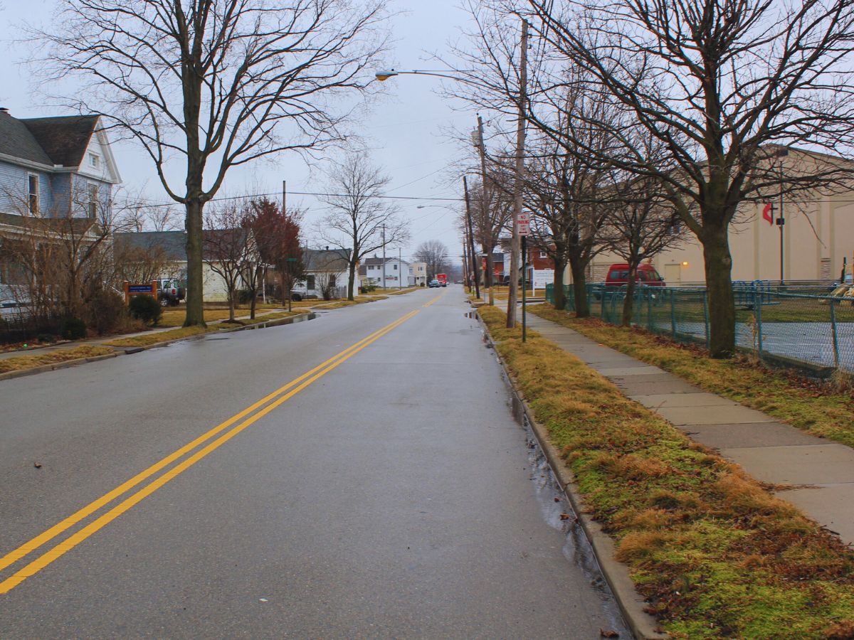 A quiet, empty Broad Street Corridor in Fairborn, OH, lined with bare trees and buildings on a cloudy day.