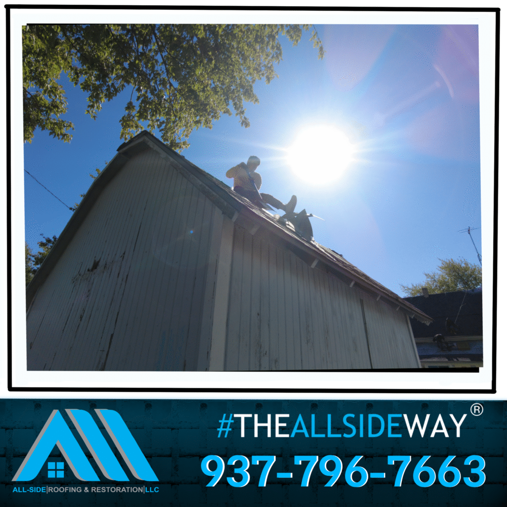 A worker repairs the roof of a white building under bright sunlight; Roofing company near me in Maineville, OH logo and contact info are displayed.