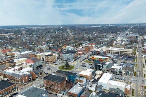 Aerial view of Miami County, Ohio downtown with a roundabout, commercial buildings, and residential areas in the background.