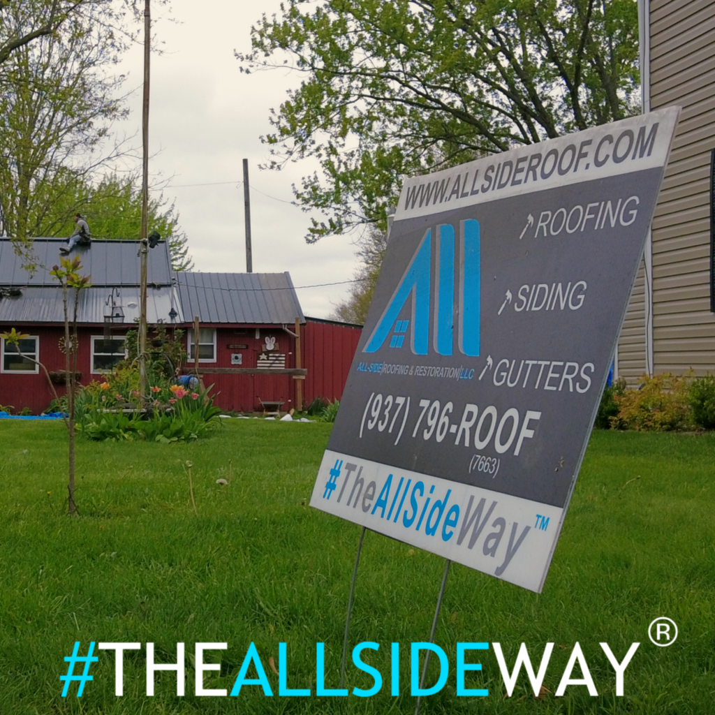 A yard sign for All Side Roofing in Fairfield, OH advertises roof repair, siding, and gutters with contact details in front of a house.