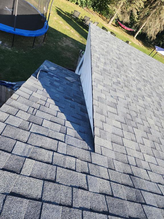 Gray asphalt shingle roof with a valley in Springboro, OH; backyard trampoline and outdoor furniture suggest recent roof replacement.